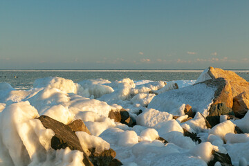 Ice-covered sea cliffs. The beauty of the winter sea.