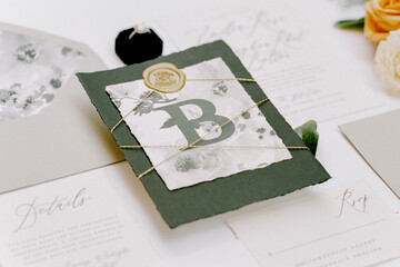 Elegant wedding invitation suite featuring greenery and floral elements displayed on a soft background