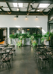 Elegant indoor space with lush greenery and chairs arranged for an event in a modern venue