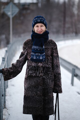 A woman walking on the snowy sidewalk in winter.