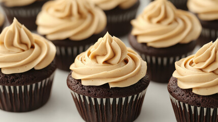 A lineup of luxurious chocolate cupcakes topped with smooth caramel frosting, piped in an elegant rosette pattern