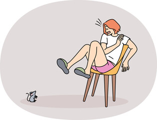 Mouse scares woman jumped onto chair out of fear and experiences musophobia at sight of rodent. Hysteria and panic in young girl who saw small mouse in house, causing awe and horror