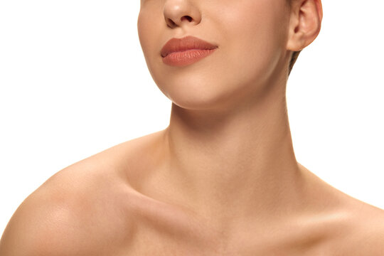 Close-up of young woman's chin and defined jawline with healthy, smooth, lifted skin against white studio background. Concept of natural beauty, self-care, anti aging products, wellness.
