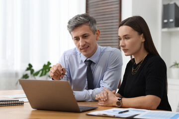 Coworkers working together at table in office