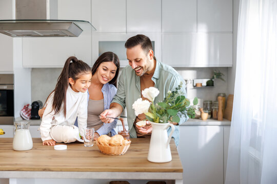 Family bonding over breakfast preparation in a modern kitchen, enjoying a fun and joyful activity together