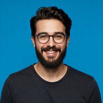 Portrait of a smiling bearded man in glasses looking at camera
