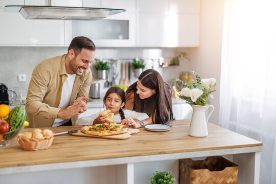 Family enjoys cooking together in modern kitchen during a sunny afternoon