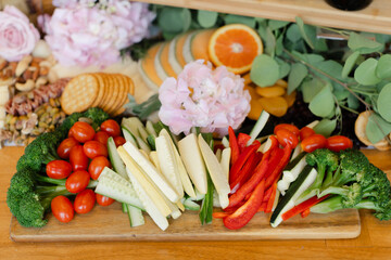 Colorful vegetable platter featuring fresh produce and flowers at a casual gathering in a cozy setting