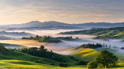 Fototapeta premium Serene Morning Landscape with Rolling Hills, Lush Green Fields, Misty Air, and Towering Mountains Under a Soft Warm Light in Tuscany, Italy