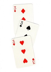 Playing cards showing three of the same value on a white background.