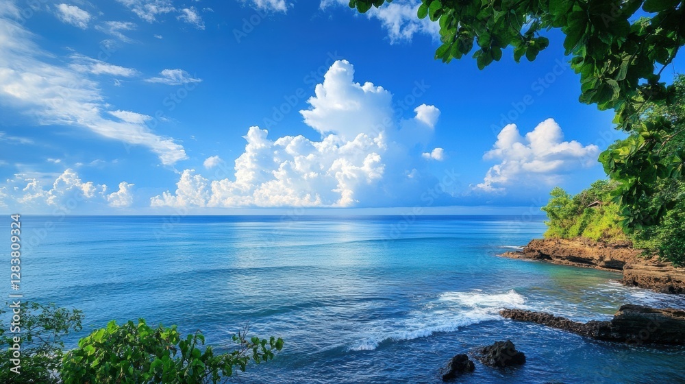 Poster serene coastal view with vibrant blue ocean and fluffy clouds near rocky shoreline in tropical setti