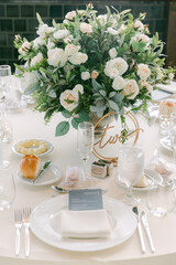 Elegant wedding reception table setting with floral centerpiece and gourmet meal on a fine day