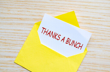 Top view of yellow envelope on a wooden surface with a white card partially pulled out with text...