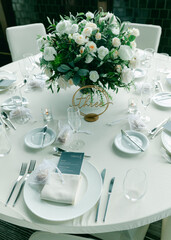 Elegant dining table setup for a wedding reception featuring floral centerpieces and fine tableware during a daytime event