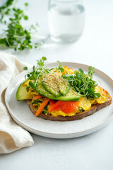 Vegetable avocado toast on sourdough with microgreens and sesame seeds