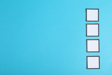 Empty checkboxes on light blue background, flat lay. Space for text