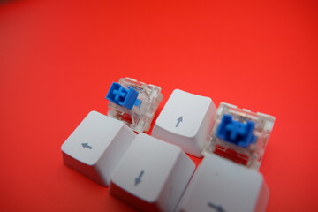 Blue Mechanical Keyboard Switch with Keycaps Isolated on Red Background