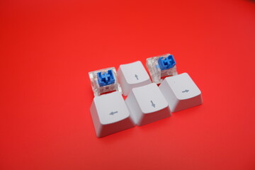 Blue Mechanical Keyboard Switch with Keycaps Isolated on Red Background