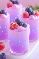 Vibrant berry desserts with creamy pink and purple layers in decorative glasses