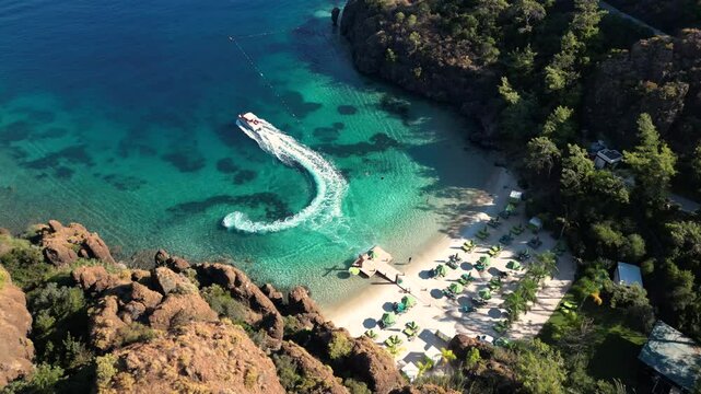 Secluded beach near Datca with a speedboat, turquoise water, rocky cliffs, and lush greenery, oe 01