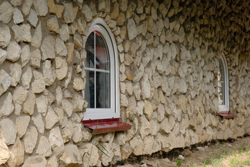 The stone wall with arched windows in the antique style.