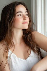 Side profile of a woman with luminous skin, natural glow reflecting light, neutral soft glam, aesthetic portrait photography captured in a stunning moment.