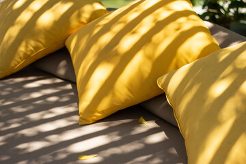 Outdoor Patio Lounge Bed with Yellow Pillows under beautiful shadow