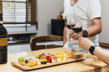 Couple hand clicking glasses of wine celebration.