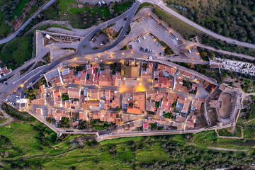 Amazing aerial view of the medieval village of Monsaraz, Alentejo, Portugal. Beautiful landscape at sunset. Historic castle, tourist attraction and holiday travel destination.