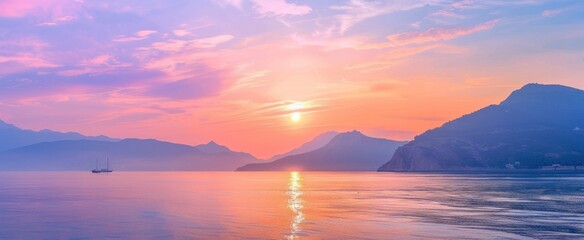 Fototapeta premium Sunset in pink and gold tones. Evening sun hides behind mountains against the backdrop lake sea water surface.