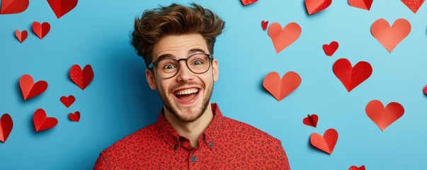 Happy young man smiling against blue background with red heart decorations