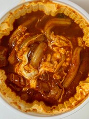 Yeoptteok, a spicy Korean rice cake dish combining chewy tteokbokki with intensely flavored sauce, often paired with fish cakes and boiled eggs. Known for its fiery heat and bold flavors.
