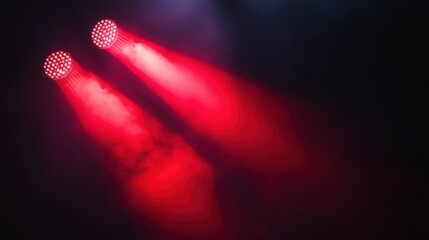 Dramatic red stage lighting with bright spotlight beams and smoke effects