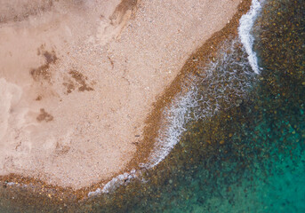 View from above using a drone from a perpendicular viewpoint, the natural appearance of the shoreline at Cristo Rei Beach, Dili, Timor Leste.