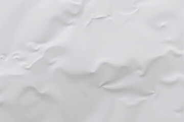 Abstract white surface with subtle folds and variations in texture, creating a minimalist background.