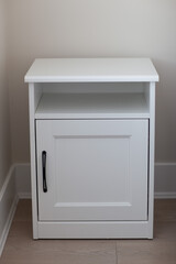 white bedside table with black fittings in the bedroom, close-up