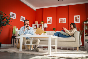 adult beard man talk on mobile phone while sit on the floor at home