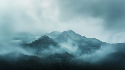 Obraz premium A mountain range shrouded in a pale, dull blue-gray sky, heavy clouds rolling in with the threat of a hurricane. The scene feels eerie, as if nature is about to unleash its fury (1)