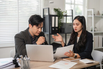 Colleagues engaged in a financial strategy discussion in a bright office setting.