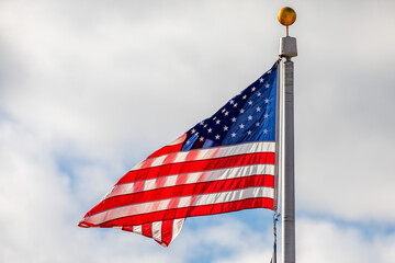 American flag waving with clouds in the background