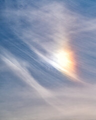Die Sonne bricht sich farbig in Schleierwolken