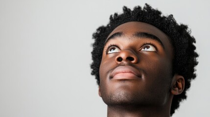 Obraz premium Man's face, looking up, with black hair and facial features clearly visible against a white background.