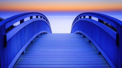 Obraz premium Curved Wooden Bridge Leading to the Ocean at Colorful Sunset with Tranquil Waterscape