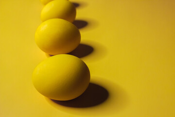 Easter background with bright yellow eggs. Easter composition. Top view of yellow Easter eggs on the yellow background.