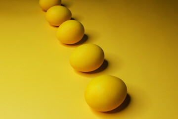 Easter background with bright yellow eggs. Easter composition. Top view of yellow Easter eggs on the yellow background.