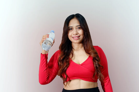 Image of a Asian woman cheerful young sports woman posing isolated indoors holding drinking water