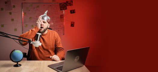 Bearded man in aluminum foil hat Worried Tired having headache and problem while Live streaming,...