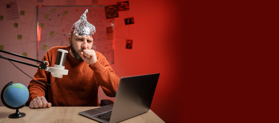 Bearded man in aluminum foil hat coughing holding hands while Live streaming, presenter with...