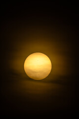 A radiant golden sun shines through soft clouds during a captivating sunset or sunrise.