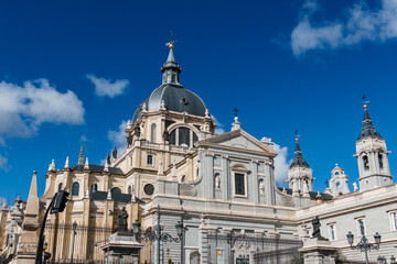 Majestic view of the Almudena Cathedral dome rising against a clear blue sky in Madrid.